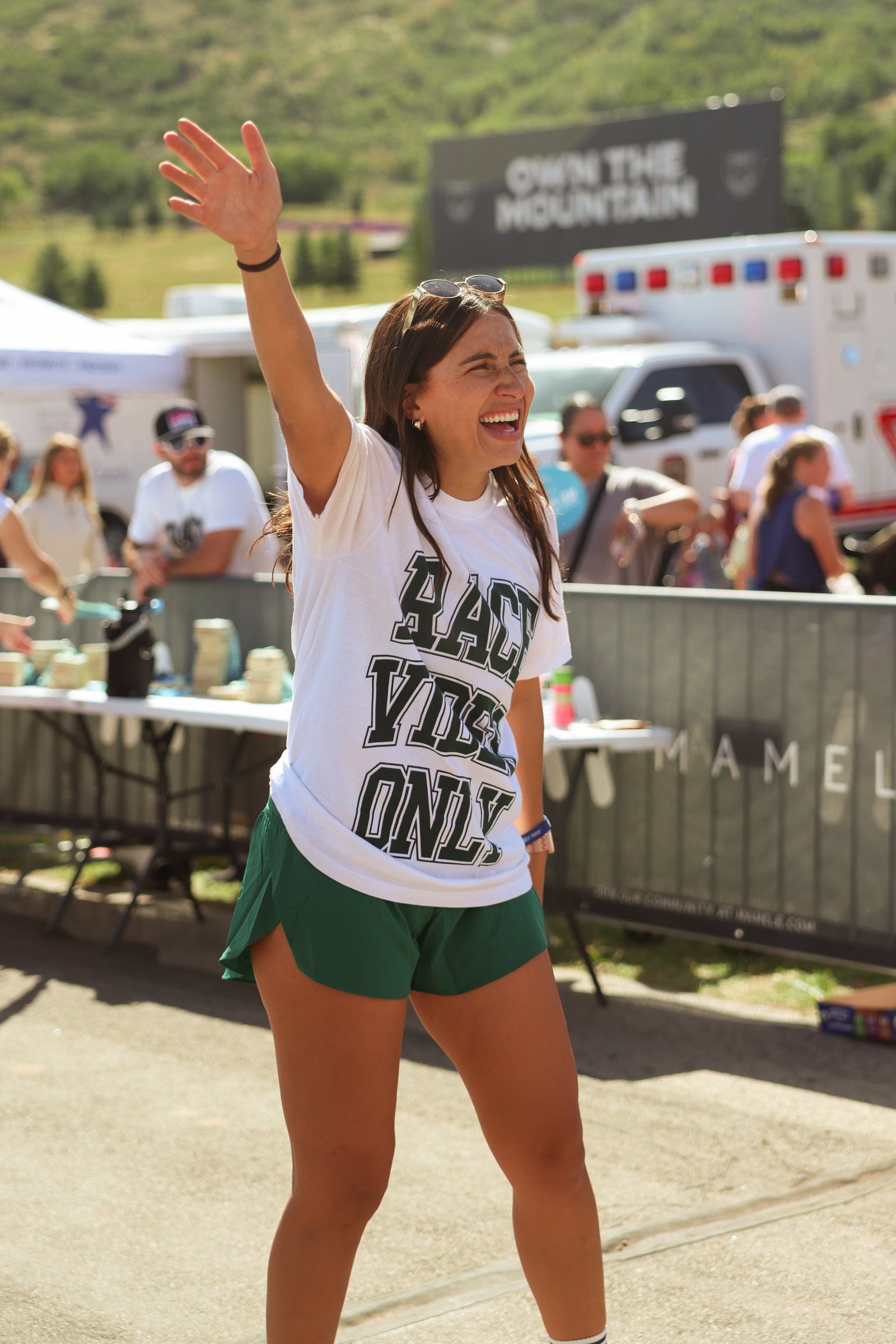 A racer celebrating with both arms up just past the finish.