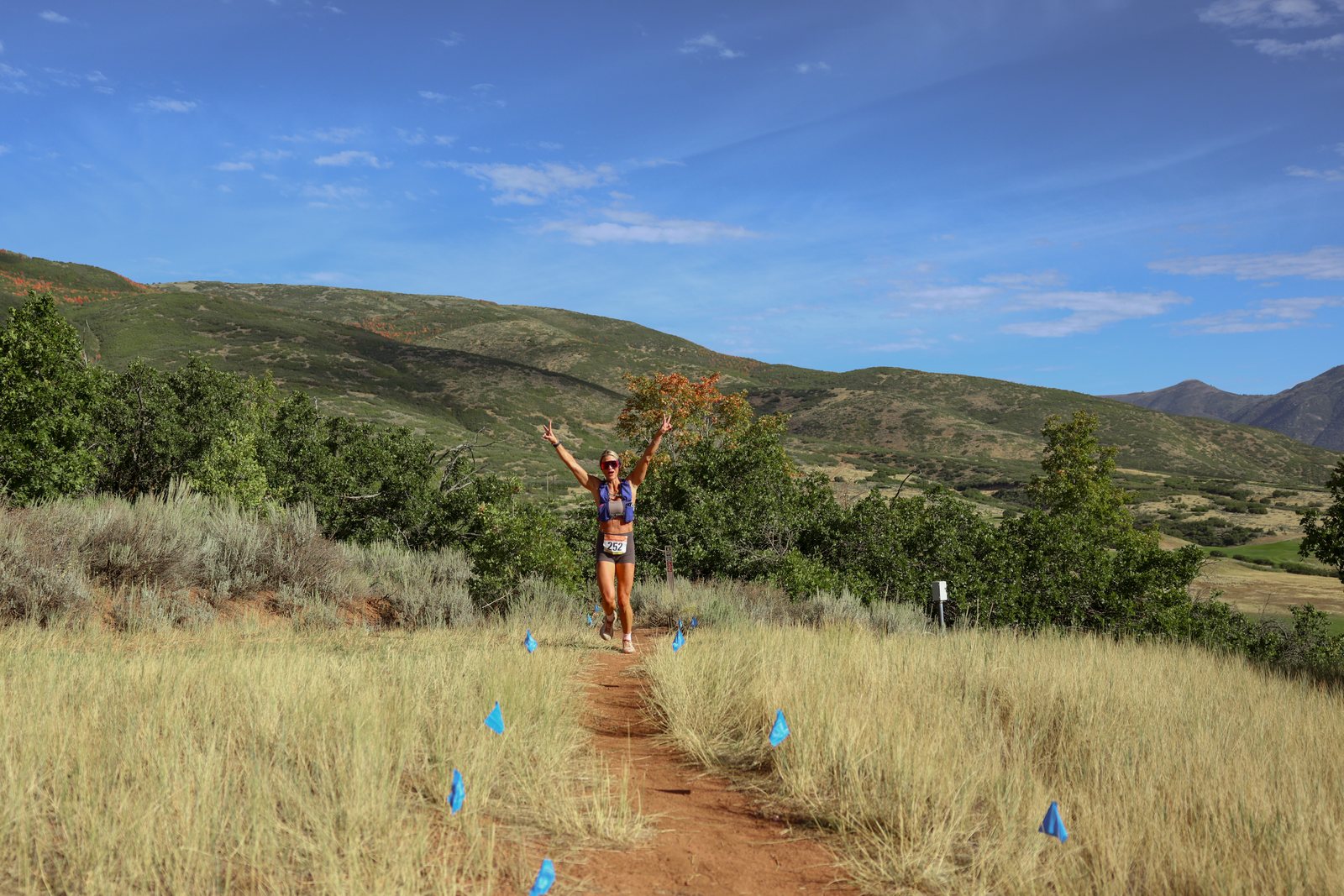 A single runner on the ridge line against open sky.