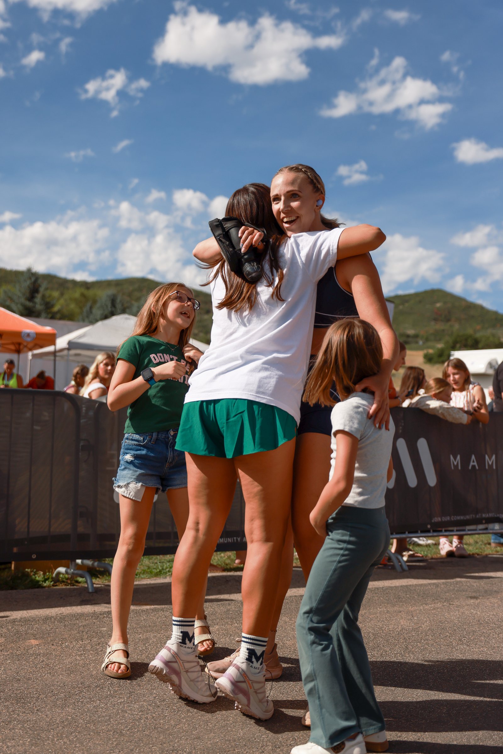 Two women holding each other at the finish line.